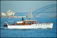 The  bridge deck motor cruiser KU-RING-GAI,  formerly MISS EVE, with the Sydney Harbour Bridge …