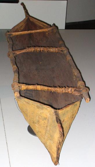 The yellow ochre finish is a distinct feature of this child's canoe.